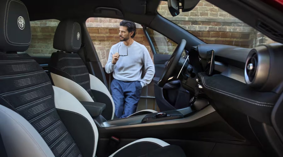 Interior cabin view of the 2026 Alfa Romeo Tonale featuring premium two-tone seats with embroidered Alfa Romeo headrest crests and center console DNA selector dial in Ramsey, NJ.