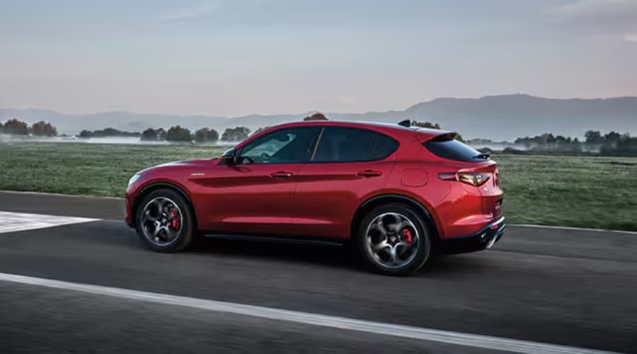 Red 2026 Alfa Romeo Stelvio luxury performance SUV driving along an open road, highlighting Q4 AWD capability for Bergen County and North Jersey commuters