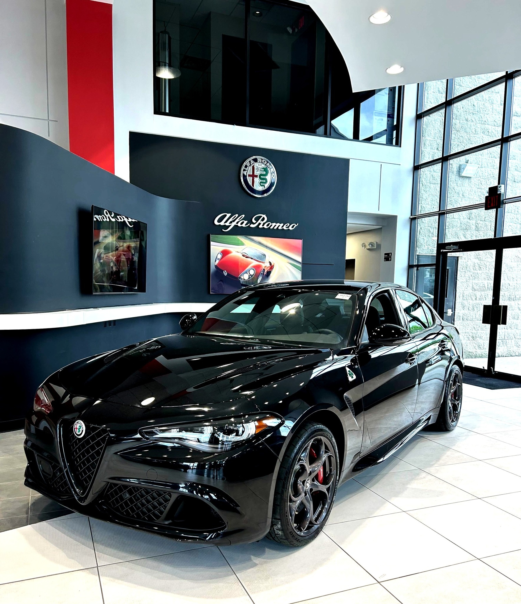 Front profile of a 2026 Alfa Romeo Stelvio driving through Upper Saddle River showcasing sleek lines and signature V-Scudetto grille