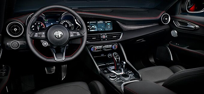 2023 Giulia Estrema interior in black, view of dashboard with steering wheel and instrument panel, and center console.
