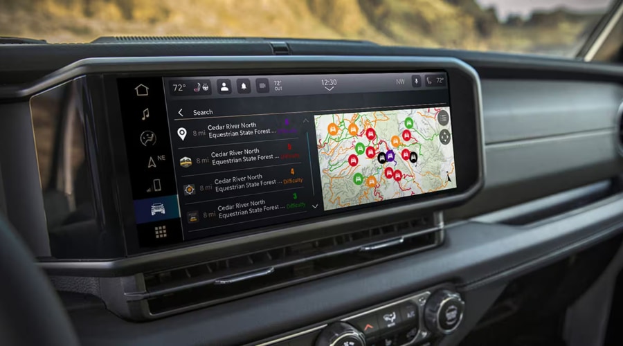 Close up view of the landscape-oriented 12.3-inch Uconnect 5 touchscreen display on the dashboard of a 2026 Jeep Wrangler, showing off-road trail maps, difficulty ratings, and GPS navigation data