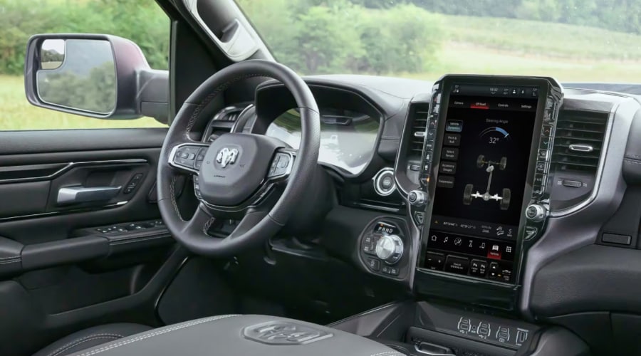 2026 Ram 1500 interior showing the Uconnect 5 vertical touchscreen displaying vehicle dynamics and drivetrain settings, available at Ramsey CJDR in Bergen County, NJ.
