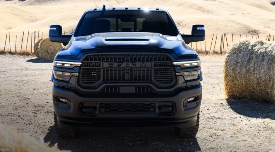 Front view of a dark black 2026 Ram 2500 Heavy-Duty truck featuring an aggressive blacked-out grille, LED headlights, and extended towing mirrors parked on a job site, available for commercial towing in Ramsey, NJ and Bergen County. 