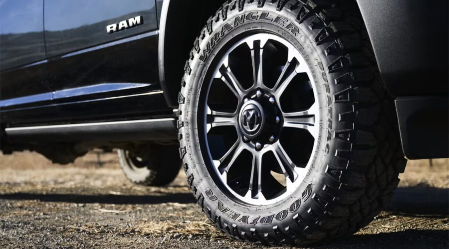 Close-up of Goodyear Wrangler DuraTrac all-terrain tire mounted on a 2026 Ram 2500 Heavy-Duty alloy wheel with Ram center cap, offering off-road traction and payload stability for contractors in Ramsey, NJ and Bergen County.