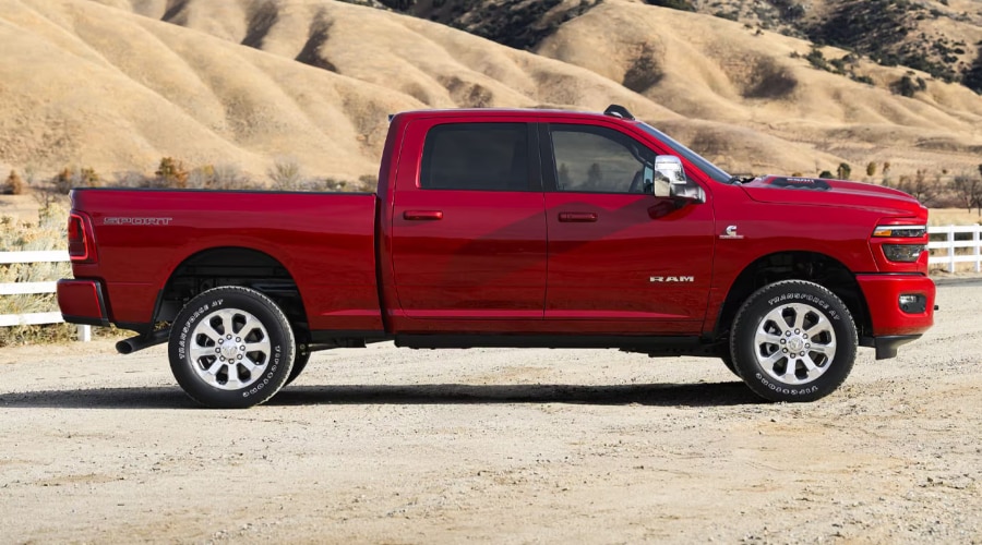 Side profile view of a red 2026 Ram 2500 Crew Cab Sport with 6.7L Cummins Turbo Diesel badging, showcasing heavy-duty bed payload capacity and ground clearance for contractors in Ramsey, NJ and Bergen County. 