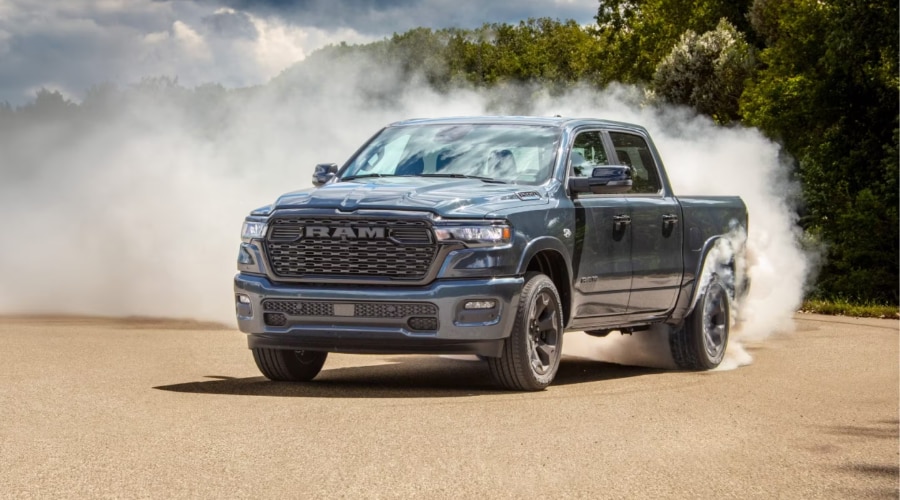 Dark slate gray 2026 Ram 1500 truck performing a high-power tire burnout surrounded by white smoke, demonstrating raw performance available at Ramsey CJDR off Route 17 in Bergen County, NJ.