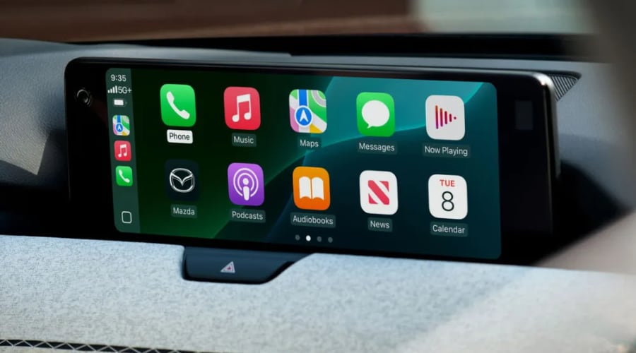 Widescreen 12.3-inch center infotainment display running Apple CarPlay navigation apps on a stitched fabric dashboard inside a 2026 Mazda CX-90 at Ramsey Mazda in Ramsey, NJ.