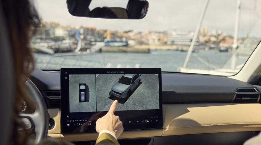 Driver interacting with the 360-degree View Monitor on the central infotainment touchscreen display inside a 2026 Mazda CX5 SUV cockpit in Bergen County, NJ.