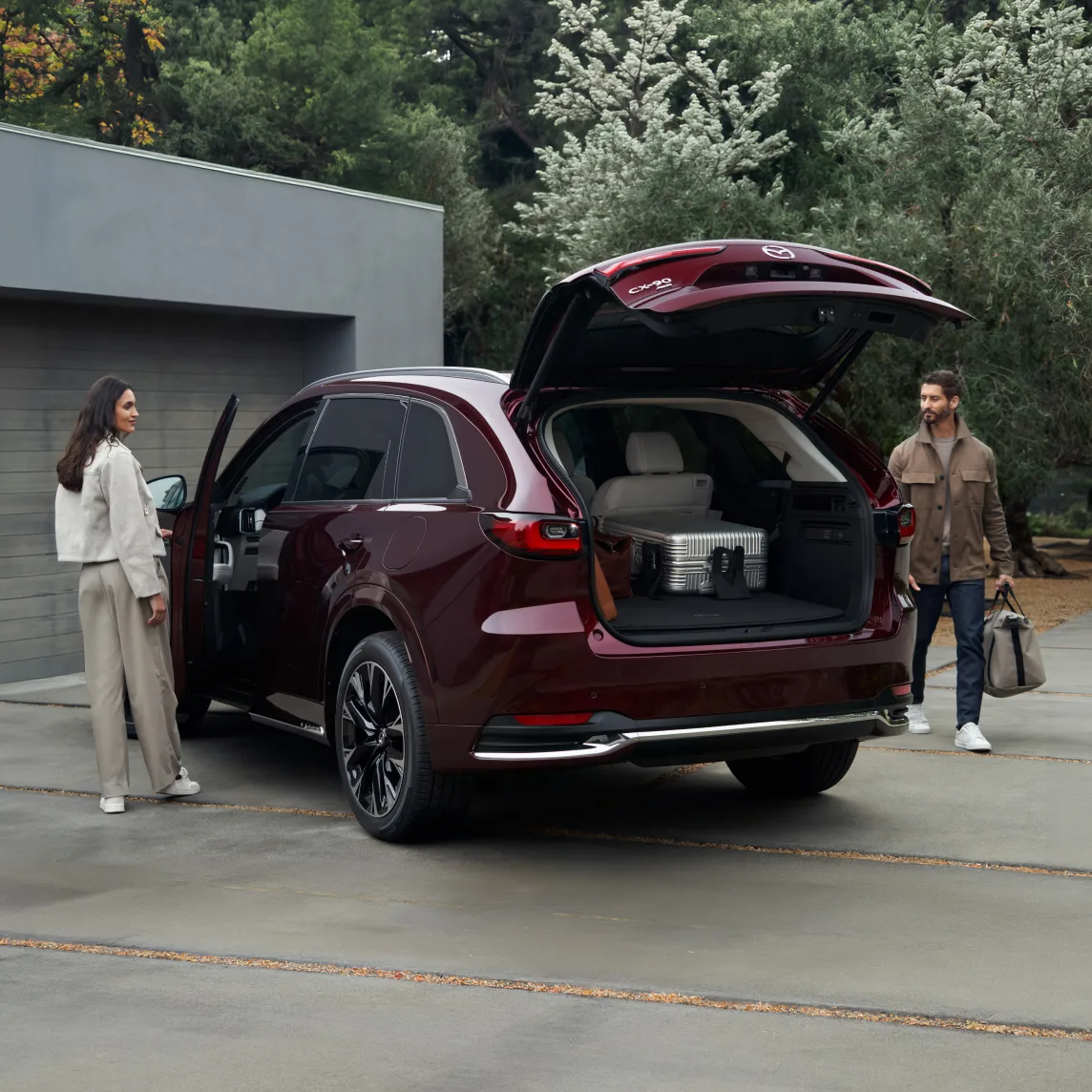 Rear angle of the Mazda CX-90 in Jet Black Mica with dark alloy wheels.