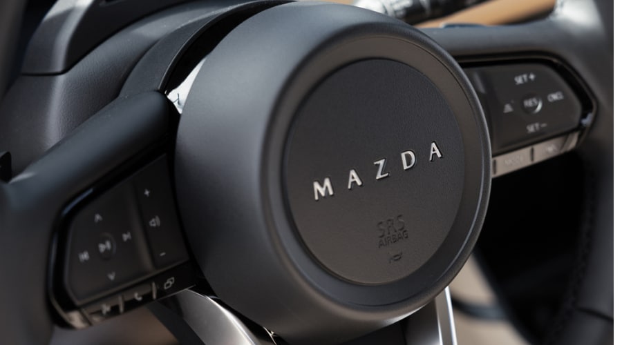 Close-up of 2026 Mazda CX5 steering wheel controls for adjusting Mazda Radar Cruise Control following distance and safety alerts in Bergen County, NJ.