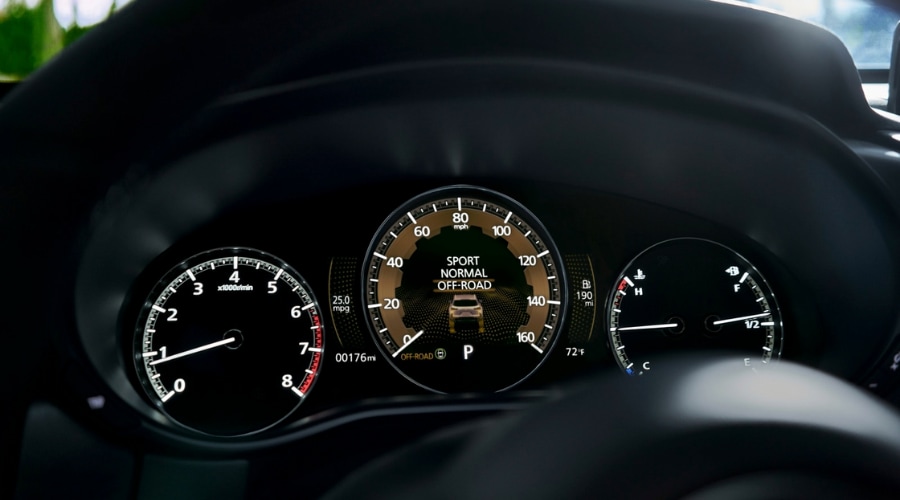 Close-up of the 2026 Mazda CX-50 digital instrument cluster and gauge display showing the Mi-Drive drive mode selection screen. 