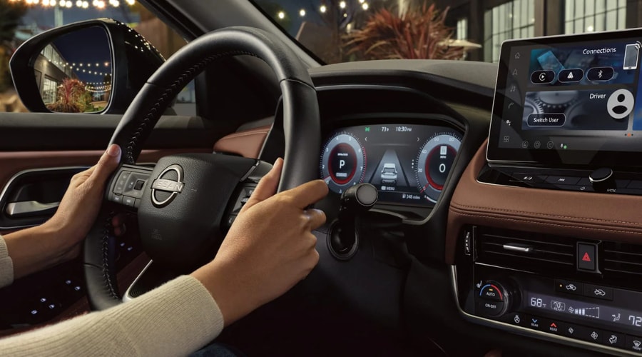 Driver cockpit view of the 2026 Nissan Rogue featuring a large touchscreen infotainment display, digital instrument cluster, and premium leather dashboard for Bergen County commutes