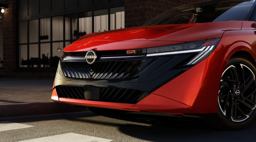 Close-up front view of a red 2026 Nissan Sentra SR highlighting the center emblem radar sensor and windshield camera system essential for Safety Shield 360 maintenance in Ramsey, NJ.