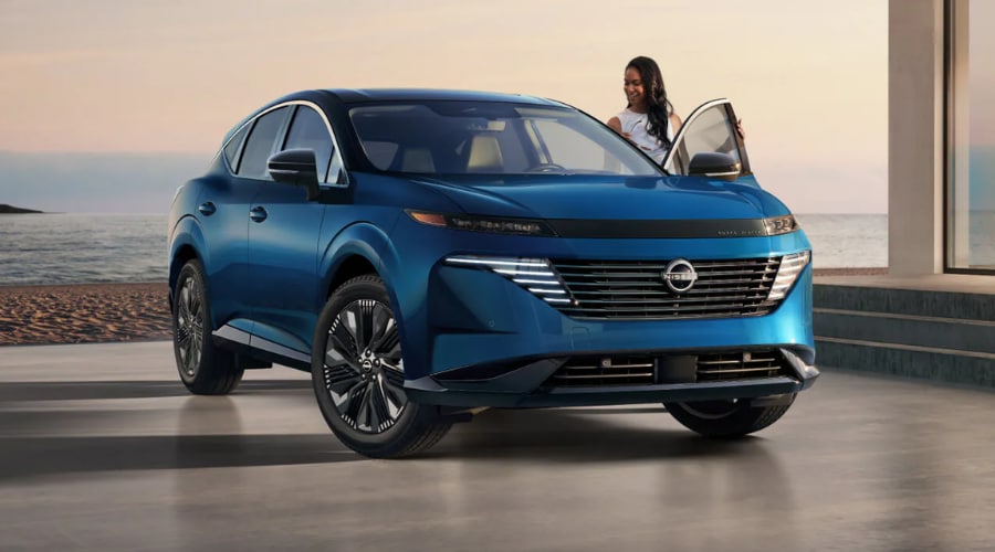 Front three-quarter view of a metallic deep blue 2026 Nissan Murano midsize SUV parked at dusk, featuring modern LED lighting and sleek front grille design for Bergen County, NJ commuters.