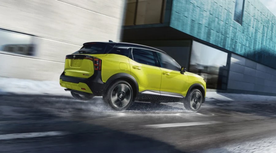 Bright yellow 2026 Nissan Kicks with Intelligent AWD navigating wet, slushy winter and autumn roads in northern New Jersey, demonstrating reliable traction and handling for local commuters.