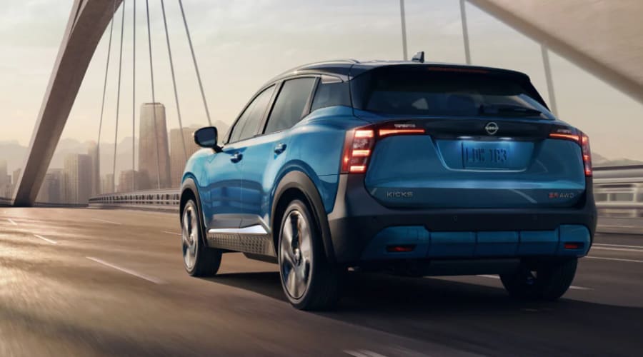 Rear view of the 2026 Nissan Kicks navigating a water covered roadway safely during a rainstorm