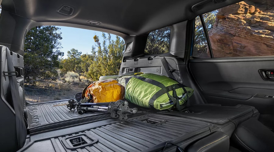 Side angle of a 2026 Subaru Outback parked at Maple Park in Ridgewood, NJ showcasing the spacious rear cargo door open