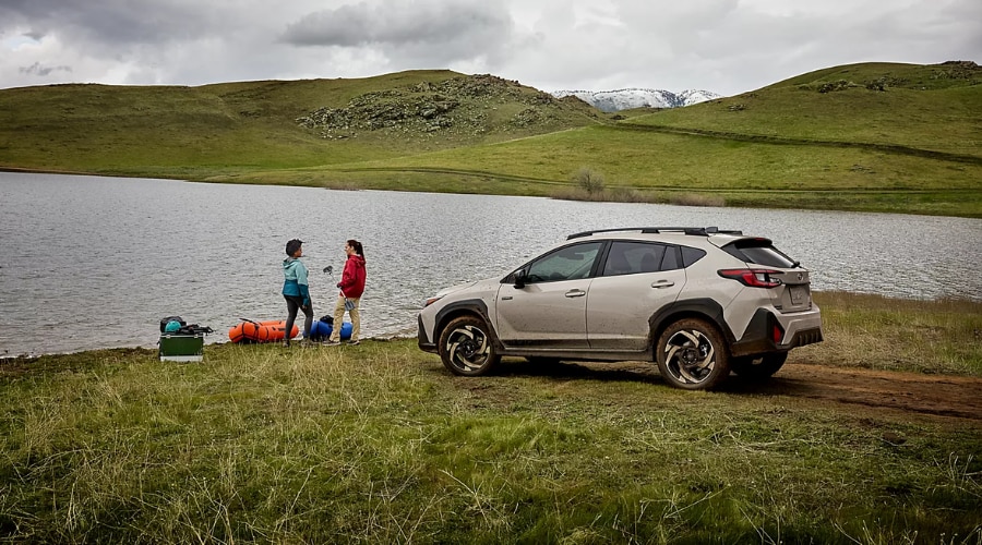Side profile of a 2026 Subaru Crosstrek parked on grass by a lake as two paddlers stand nearby in Northern New Jersey