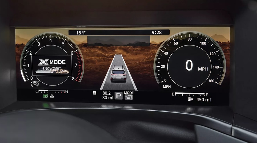 Digital driver gauge cluster display of a Subaru Outback showing X-MODE Snow/Dirt setting activated inside the tachometer dial alongside a central lane display graphic for winter driving in Mahwah and Ramsey, NJ.
