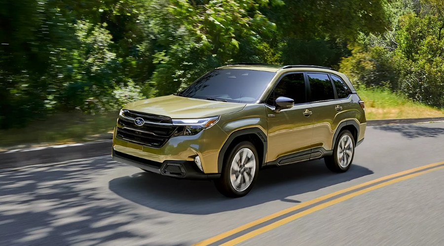 Front three-quarter view of a gold 2026 Subaru Forester cruising along a paved suburban road, demonstrating EyeSight Adaptive Cruise Control and Lane Centering on Route 17 in Ramsey, NJ.