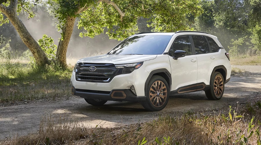 A 2026 Subaru Forester Wilderness showing its raised suspension and rugged matte black alloy wheels on a trail near Ramsey