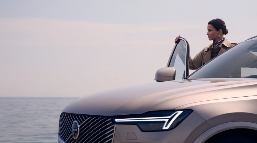 Front-end view of a 2026 Volvo XC90 featuring signature Thor's Hammer LED headlights and refined front grille as a driver enters the cabin, offering elegant Scandinavian luxury for commuters in Ramsey and Upper Saddle River, NJ.