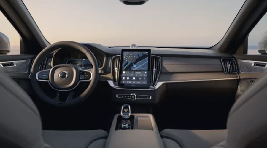 Full interior dashboard view of the 2027 Volvo XC90 luxury SUV featuring the standalone 11.2-inch vertical Google touchscreen display, 12.3-inch digital instrument cluster, linear wood trim, and ergonomic front bucket seats, available at Volvo Cars Ramsey in Ramsey, NJ.