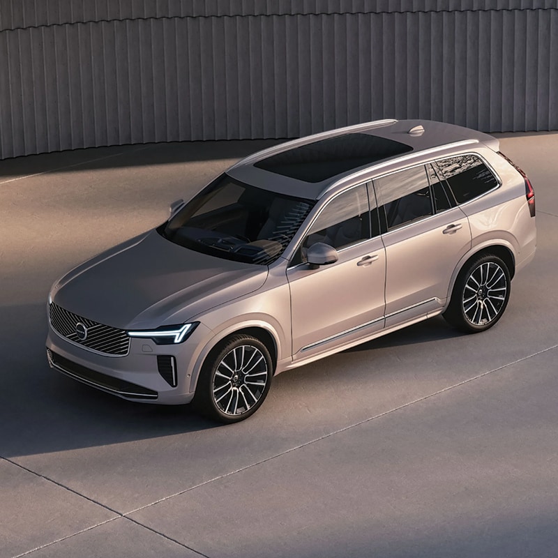 Side dynamic view of a certified pre-owned 2023 Volvo XC60 driving past scenic landscapes near Saddle River