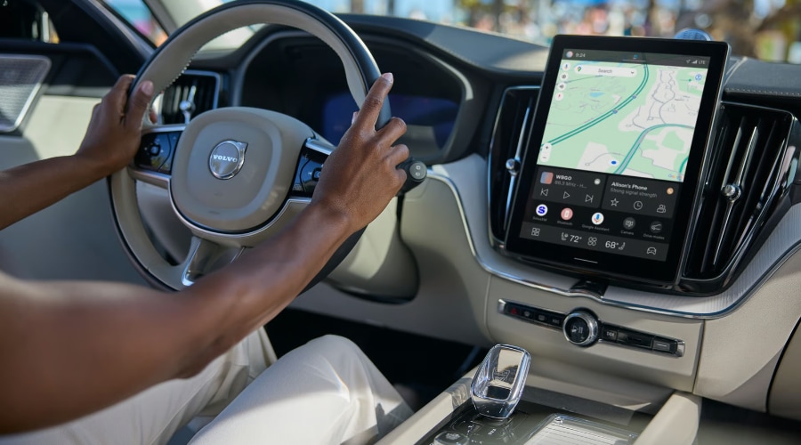 Interior view of a driver navigating with the center touchscreen display and steering wheel of the 2026 Volvo XC60 Plug-in Hybrid during a cool fall drive through Bergen County, NJ.
