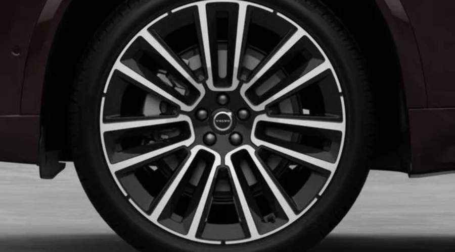 Close-up view of the 21-inch 8-multi-spoke black diamond-cut alloy wheel with central Volvo emblem on a 2027 Volvo XC90 luxury SUV, available for viewing at Volvo Cars Ramsey in Ramsey, NJ.