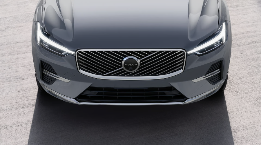 Close-up overhead view of the refreshed 2027 Volvo XC60 front fascia featuring the updated diagonal mesh grille, chrome trim accents, illuminated Thor's Hammer LED headlights, and iconic Volvo iron mark emblem at Volvo Cars Ramsey.