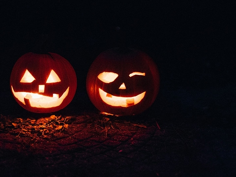 a pair of jack-o-lanterns illuminated by candles inside