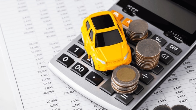 Mini car model on calculator with coins symbolizing car finance options for buying or leasing a Mitsubishi in Reading PA