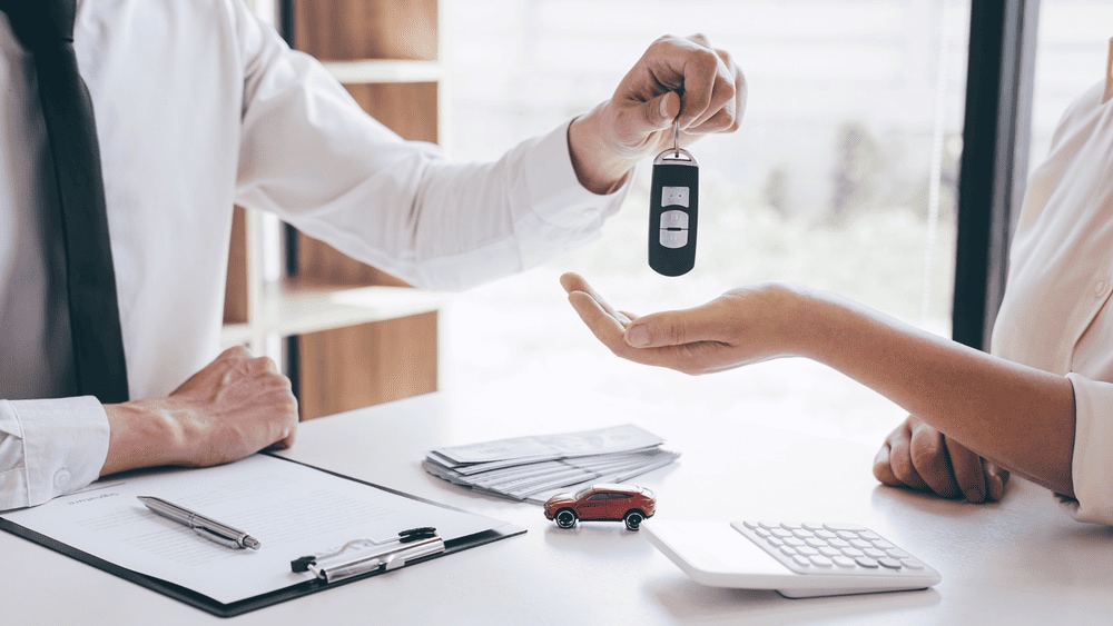 Customer receiving car keys from a preowned Mitsubishi dealer in Reading, PA showroom