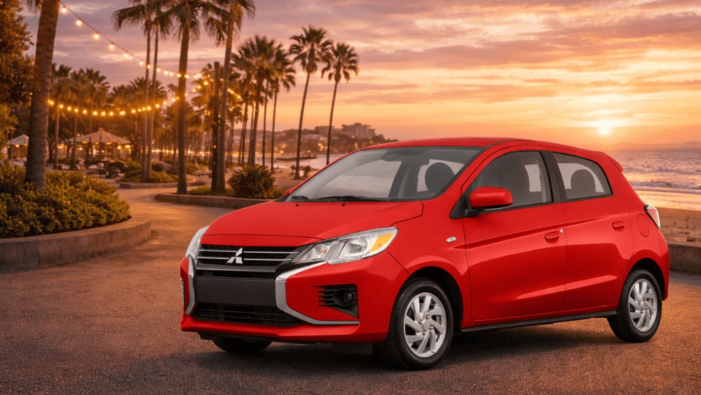 Bright red 2024 Mitsubishi Mirage parked at sunset by the beach, a fuel-efficient favorite among Reading, PA drivers.