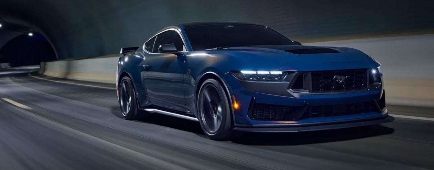 A blue 2024 Ford Mustang Dark Horse driving through a tunnel from a Ford dealer near Toledo.