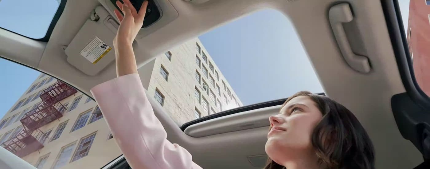 Woman opening sunroof in a 2023 Toyota Corolla Cross
