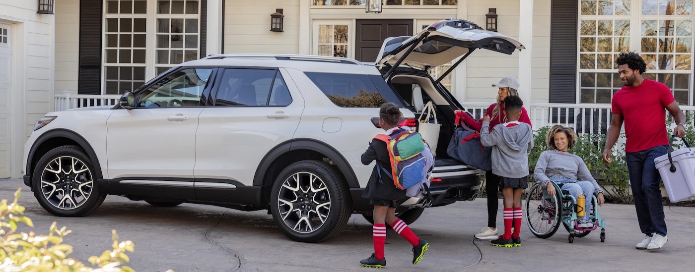 A family is shown near a white 2025 Ford Explorer for sale near Bucyrus.