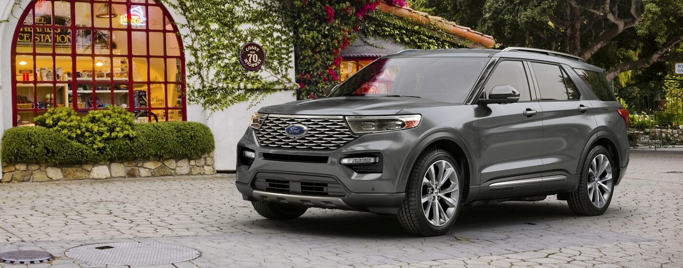 A silver 2024 Ford Explorer Platinum, a used Ford for sale in Findlay, parked in a courtyard.