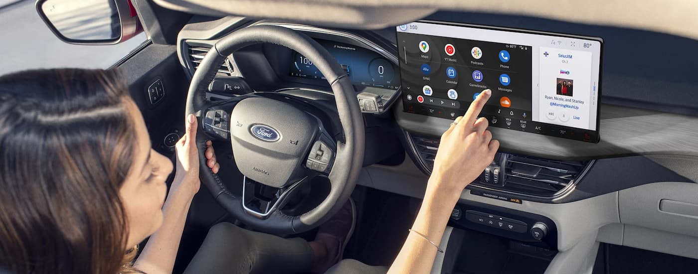 Woman using infotainment screen in a 2025 Ford Escape for sale near Vanlue.