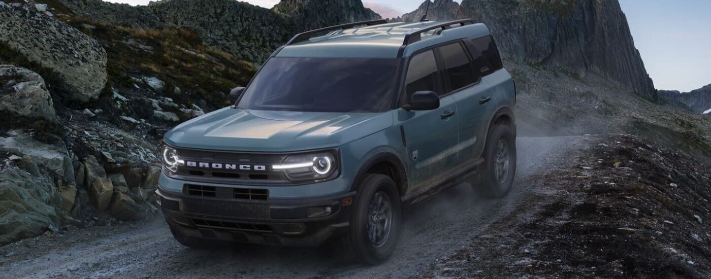 A green 2024 Ford Bronco Sport Big Bend driving down a dirt road.