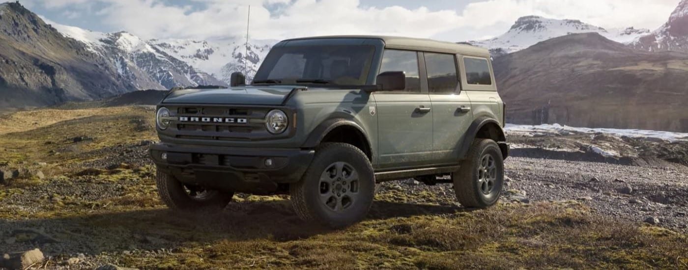 A green 2023 Ford Bronco for sale in Findlay parked in the mountains.