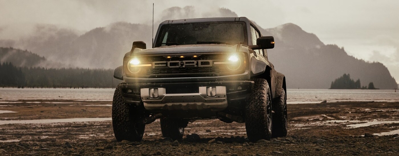 A grey 2024 Ford Bronco Raptor is shown near a lake.