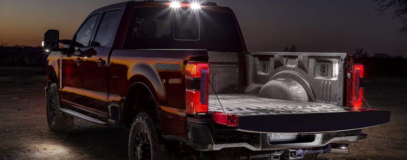 Bed of a red 2025 Ford F-250 at night.
