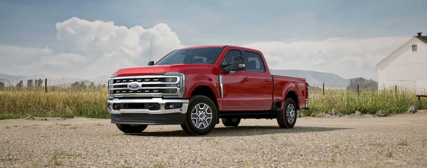 A red 2025 Ford F-250 for sale is shown parked near a house.