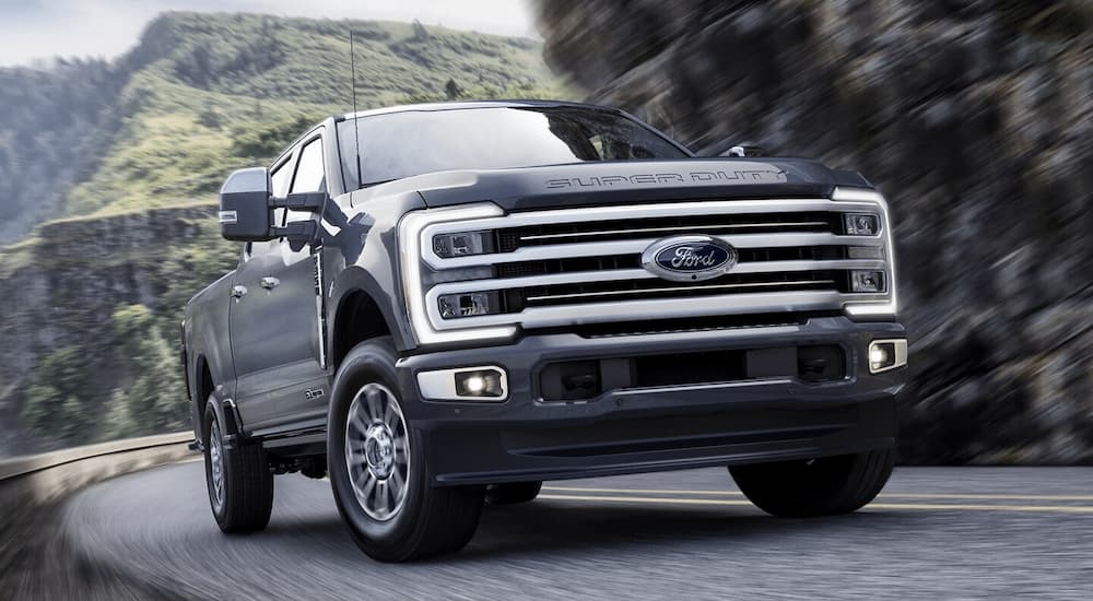 A grey 2025 Ford F-350 Platinum Plus driving on a winding road.