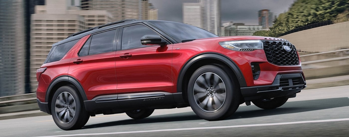 A red 2025 Ford Explorer ST Line driving down a highway