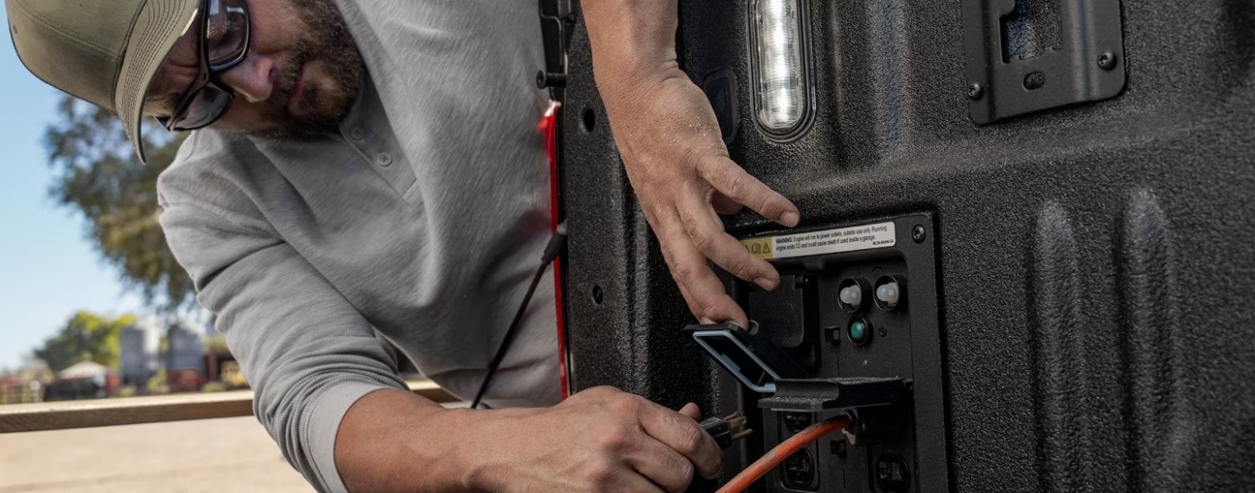 Person using an outlet in the bed of a 2025 Ford F-150