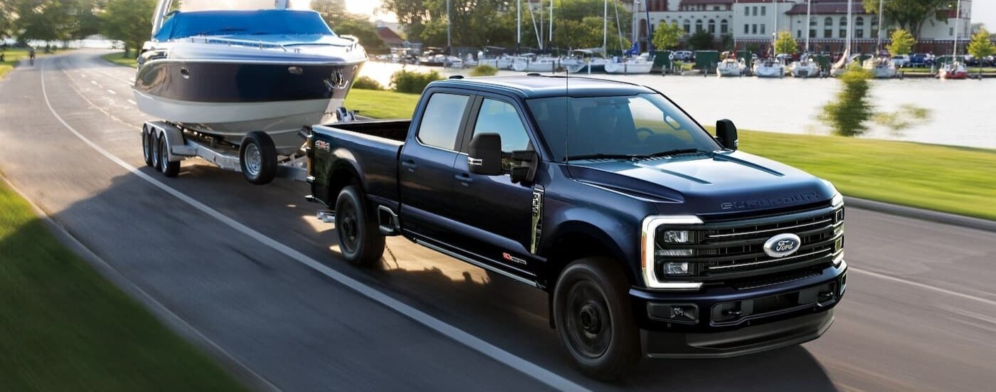 A blue 2025 Ford F-350 for sale in Findlay is shown towing a boat.