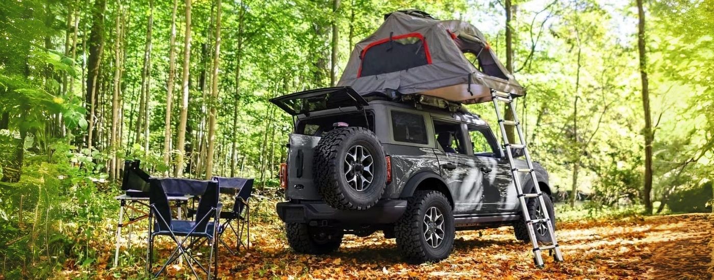 A grey 2023 Ford Bronco is shown at a campsite.